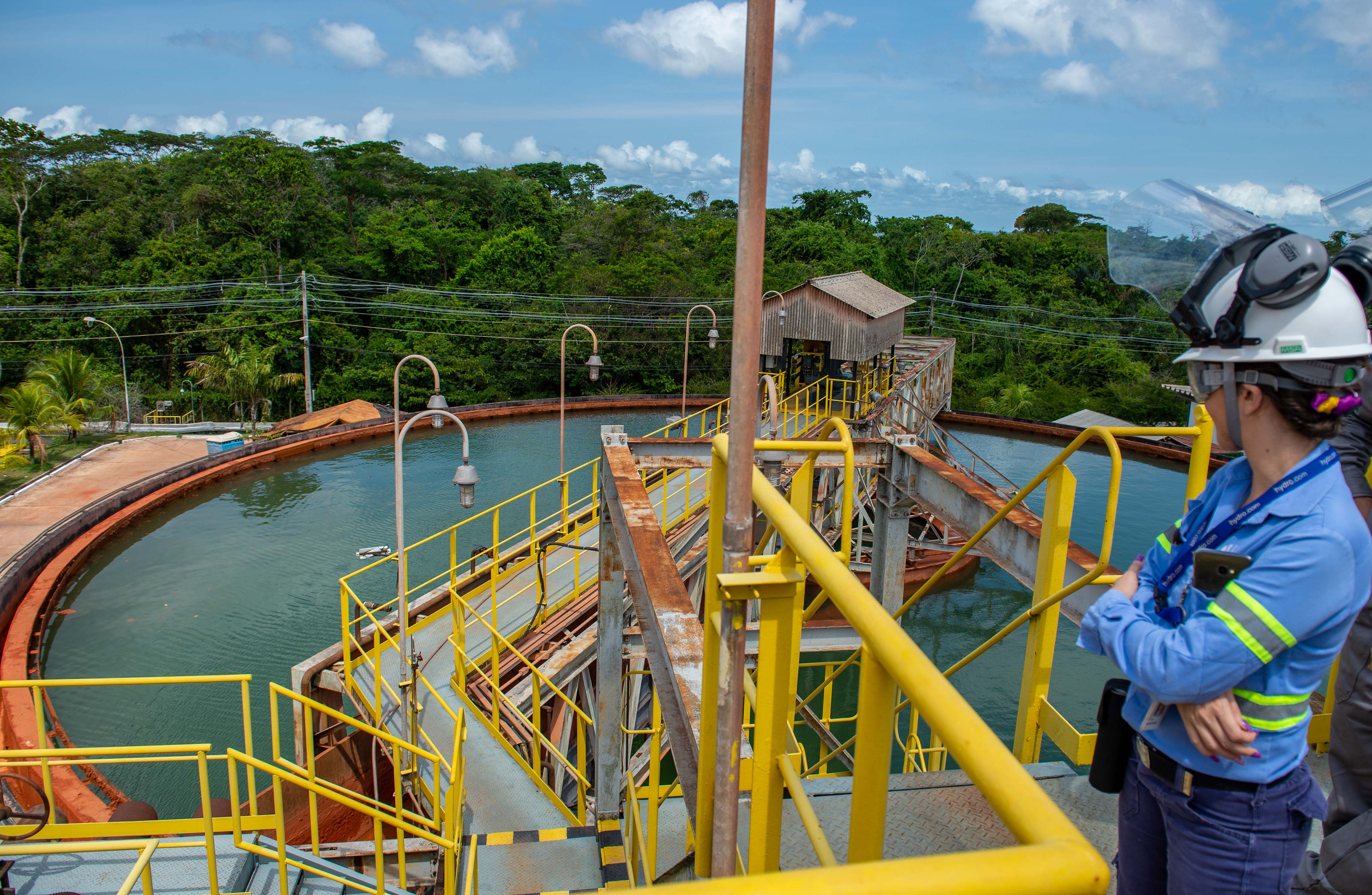 a woman wearing a helmet and standing on a bridge over a water basin