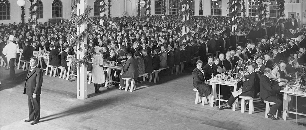 many well dressed people at long tables